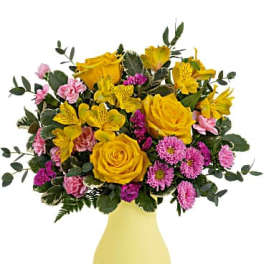 Yellow and pink mixed flower bouquet in a yellow vase