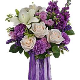 Purple and white floral arrangement in a purple glass vase