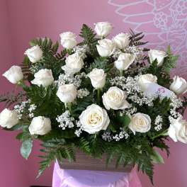 White roses arranged in a wooden box with baby's breath