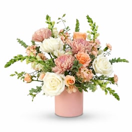 Pink and white floral arrangement in a blush vase