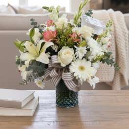 Mixed bouquet in a glass vase with white lilies, roses, and daisies