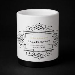 White scented candle in a black-and-white decorative jar