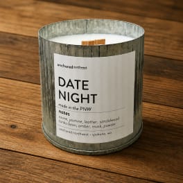 Scented candle in a metal tin on a wooden surface