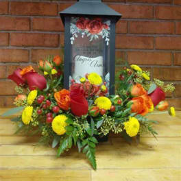 Floral arrangement around a black lantern with a candle inside