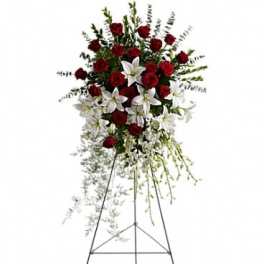 Standing floral spray with red roses and white lilies on an easel