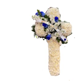White floral standing spray with blue roses and a ribbon