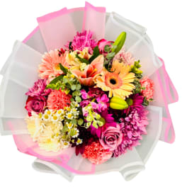 Mixed bouquet of pink, peach, and yellow flowers wrapped in white and pink paper