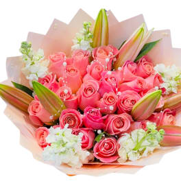 Bouquet of pink roses with white lilies and pale wrapping
