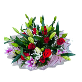 Bouquet of red roses, white baby’s breath, and pink lilies wrapped in layered pink paper