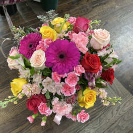 Mixed bouquet of roses, gerbera daisies, and carnations in pink, red, and yellow