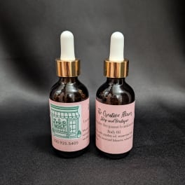 Two amber dropper bottles with pink labels on a dark background