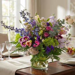 Mixed bouquet in a clear glass vase on a dining table