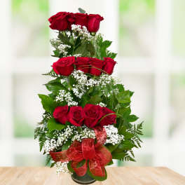 Tall arrangement of red roses with white baby's breath in a vase