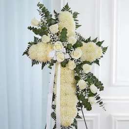 White floral standing cross with roses and mums on an easel
