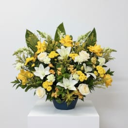 Yellow and white floral arrangement in a dark vase