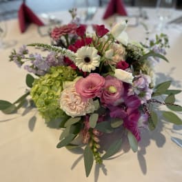 Colorful floral centerpiece with pink, white, and purple blooms on a table