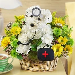 White teddy bear floral arrangement in a wicker basket with yellow daisies