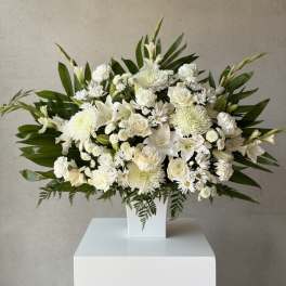 White floral arrangement in a square white vase