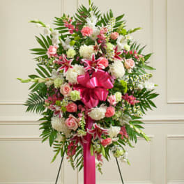 Standing floral spray with pink and white flowers and a bright pink ribbon