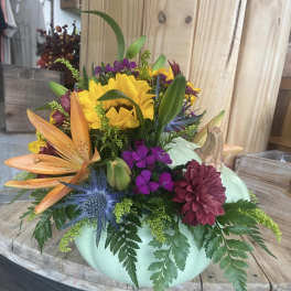 Mixed bouquet in a mint pumpkin-shaped container with sunflowers and lilies