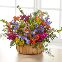 Colorful mixed flower arrangement in a woven basket