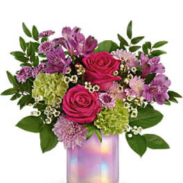 Pink roses and purple flowers in an iridescent glass vase