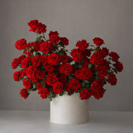 Large bouquet of red roses in a white cylindrical vase