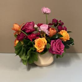 Mixed bouquet of roses and tulips in a cream vase