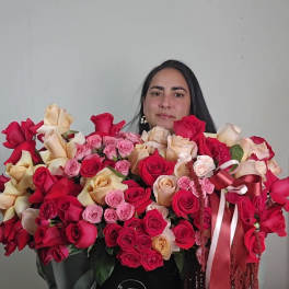 Large arrangement of red, pink, and cream roses in a black hat box