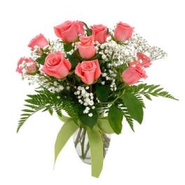 Pink roses arranged in a clear glass vase with baby's breath