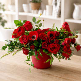 Red roses and a red poppy in a red vase