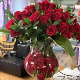 Red roses arranged in a clear glass vase