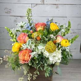 Colorful mixed flower arrangement in a wooden container