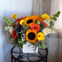 Mixed bouquet with sunflowers and gerbera daisies in a white vase