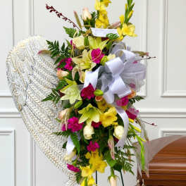 Tall floral standing spray with yellow and pink flowers on an easel