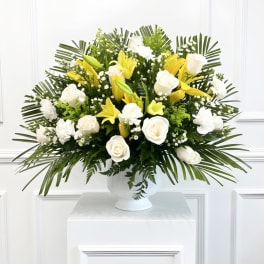 White roses and yellow lilies in a white vase