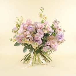 Bouquet of pastel pink and lavender roses with small white flowers