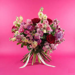 Bouquet of pink, red, and lavender roses with small filler flowers