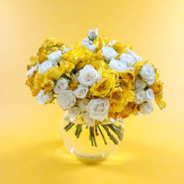Bouquet of yellow and white roses in a clear glass vase