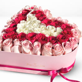 Heart-shaped box of pink, red, and white roses with a ribbon bow