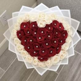 Heart-shaped bouquet of red and white roses with clear gem centers