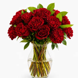 Red roses and carnations in a clear glass vase