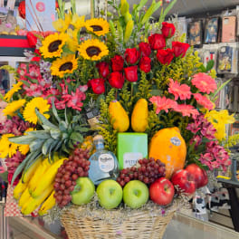 Large fruit basket with roses, sunflowers, and assorted fruit in a wicker basket