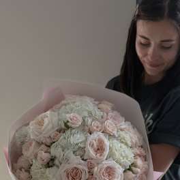 Large bouquet of pale pink roses and white hydrangeas wrapped in pink paper