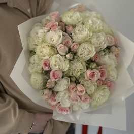 Bouquet of pale pink and white roses wrapped in white paper