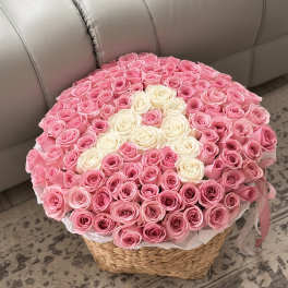 Round basket arrangement of pink and white roses