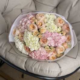 Bouquet of pastel roses and hydrangeas wrapped in white paper