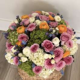 Large basket arrangement of pink, white, orange, and green flowers