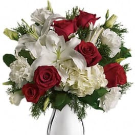 Red roses and white lilies arranged in a clear glass vase