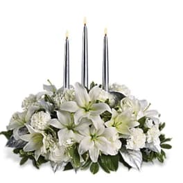 White floral centerpiece with three tall taper candles